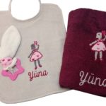 Babybox pour la naissance de Yuna composé d'un bavoir, d'une serviette de toilette personnalisée et brodée du motif fillette et la baguette magique et aussi d'un hochet de dentition assorti