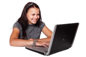 Femme devant un ordinateur passant une commande sur le site Kréa Broderie