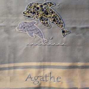 Fouta ou serviette de plage personnalisée avec une broderie de dauphin et d'un prénom