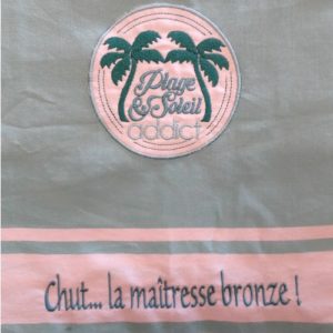 Fouta ou serviette de plage vert clair brodée du motif plage addict et personnalisable d'un prénom