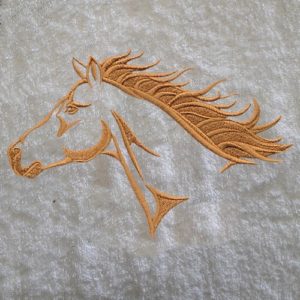 Cette jolie serviette brodée du motif QUARTER HORSE et personnalisée de son prénom enveloppera votre petite cavalière ou petit cavalier de douceur.